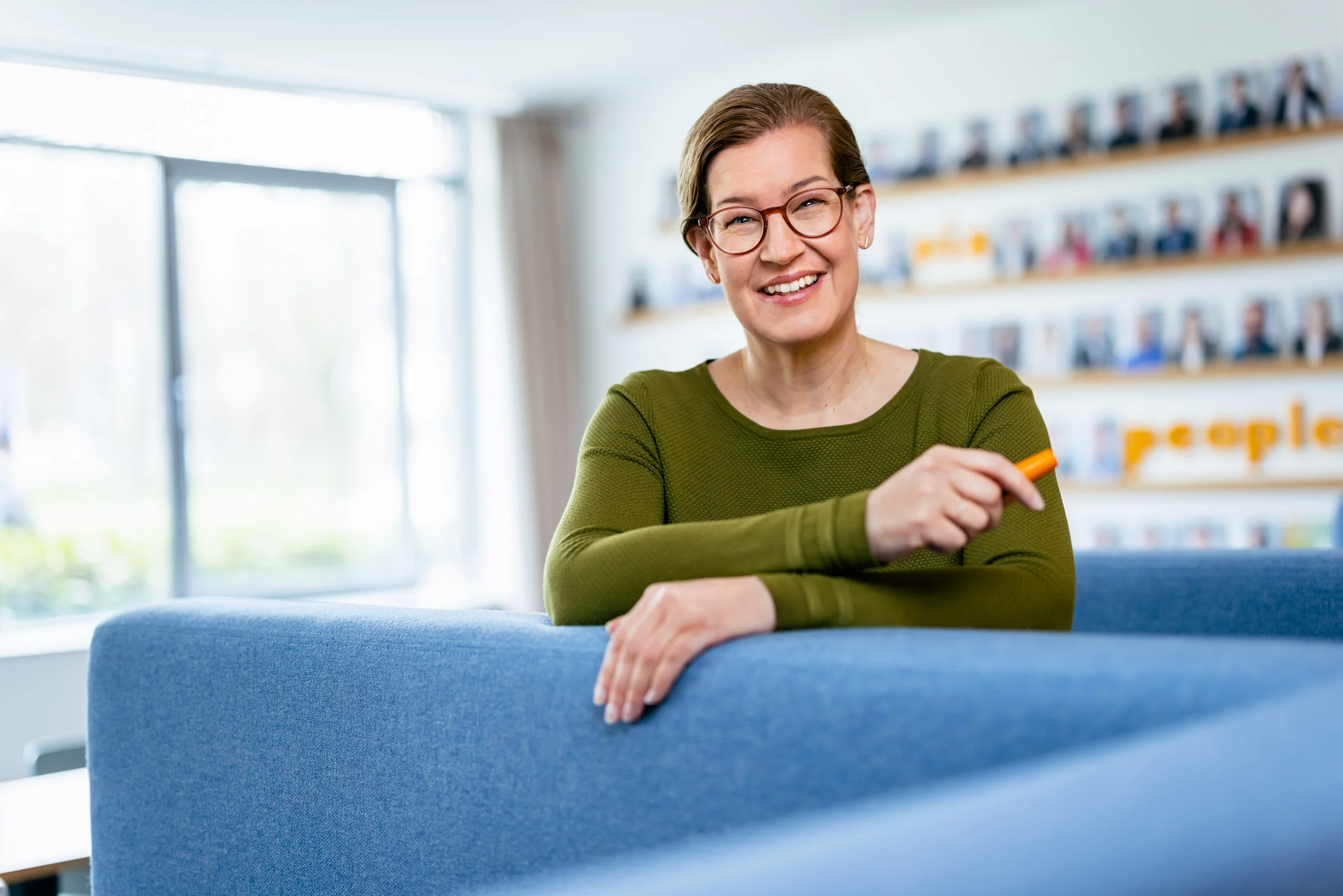 Nicole Neunhöffer stützt sich auf eine Lehne und lächelt freundlich in die Kamera.