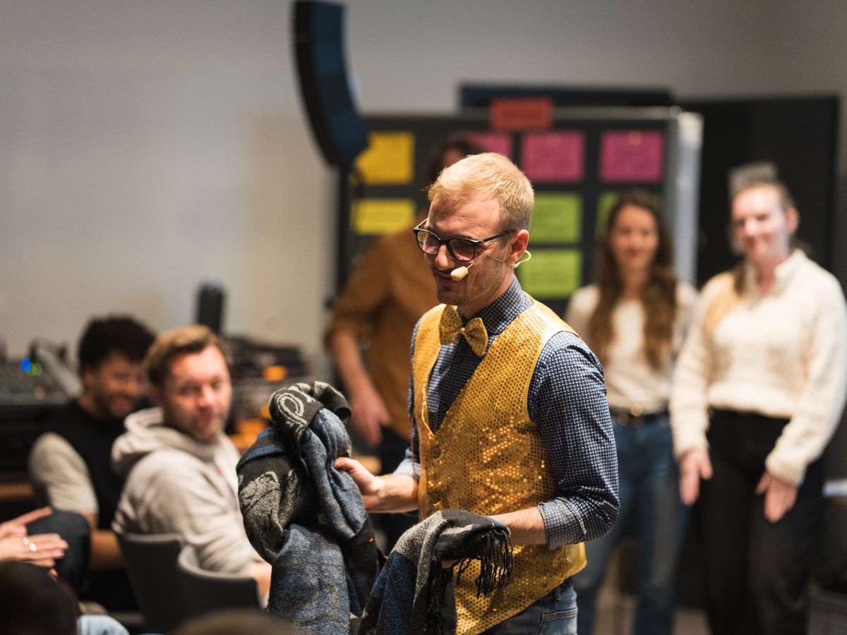 Henry auf dem viadee Seminar 2025 mit Schals in der Hand.