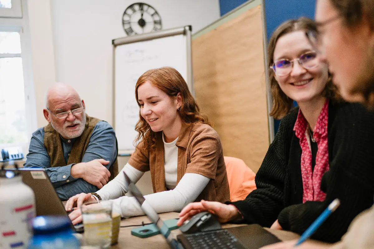 Vier Berater:innen der viadee sitzen an einem Tisch und arbeiten zusammen.