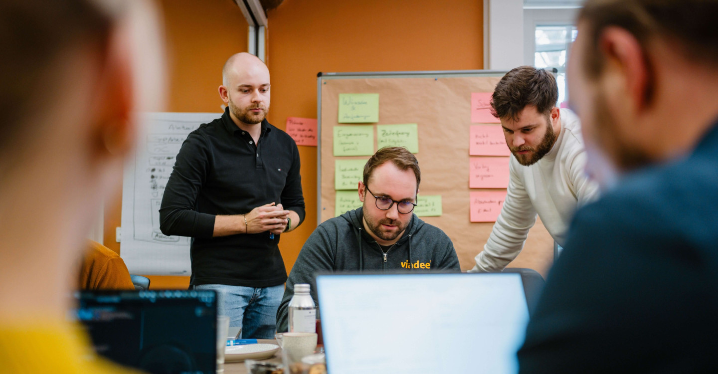 Mehrere Mitarbeiter:innen der viadee arbeiten zusammen an einem Projekt.