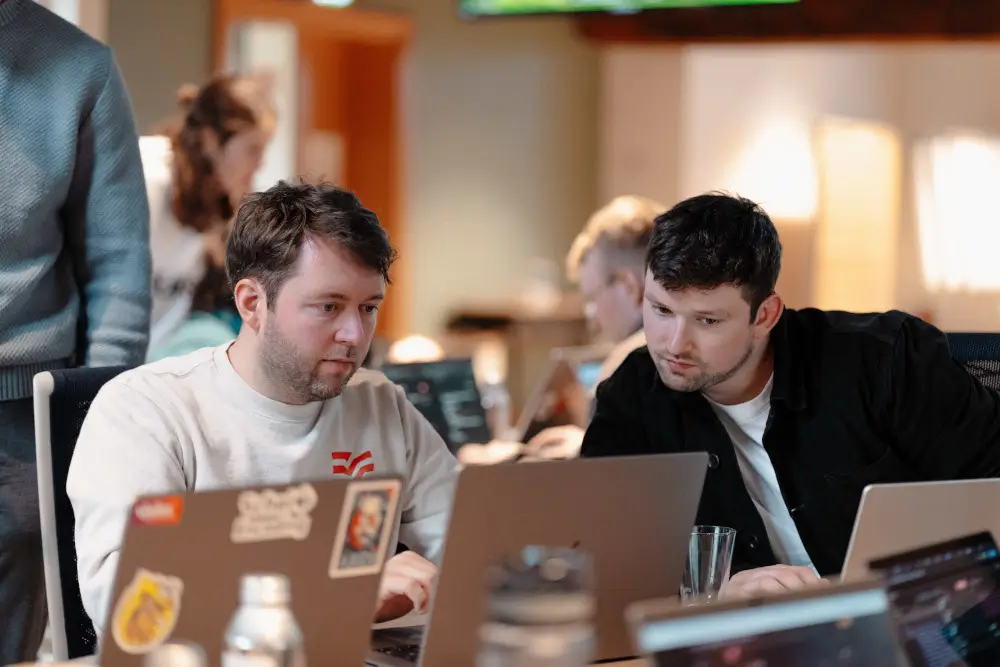 Zwei Personen unterhalten sich darüber, wie man die Effiziens von KI gestützter Softwareentwicklung misst.