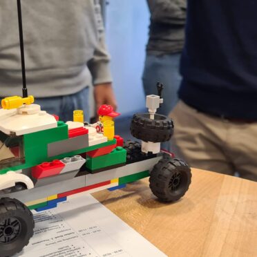 Ein LEGO-Auto steht auf einem Schreibtisch. Es verdeutlicht das Clean Code Prinzip YAGNI.