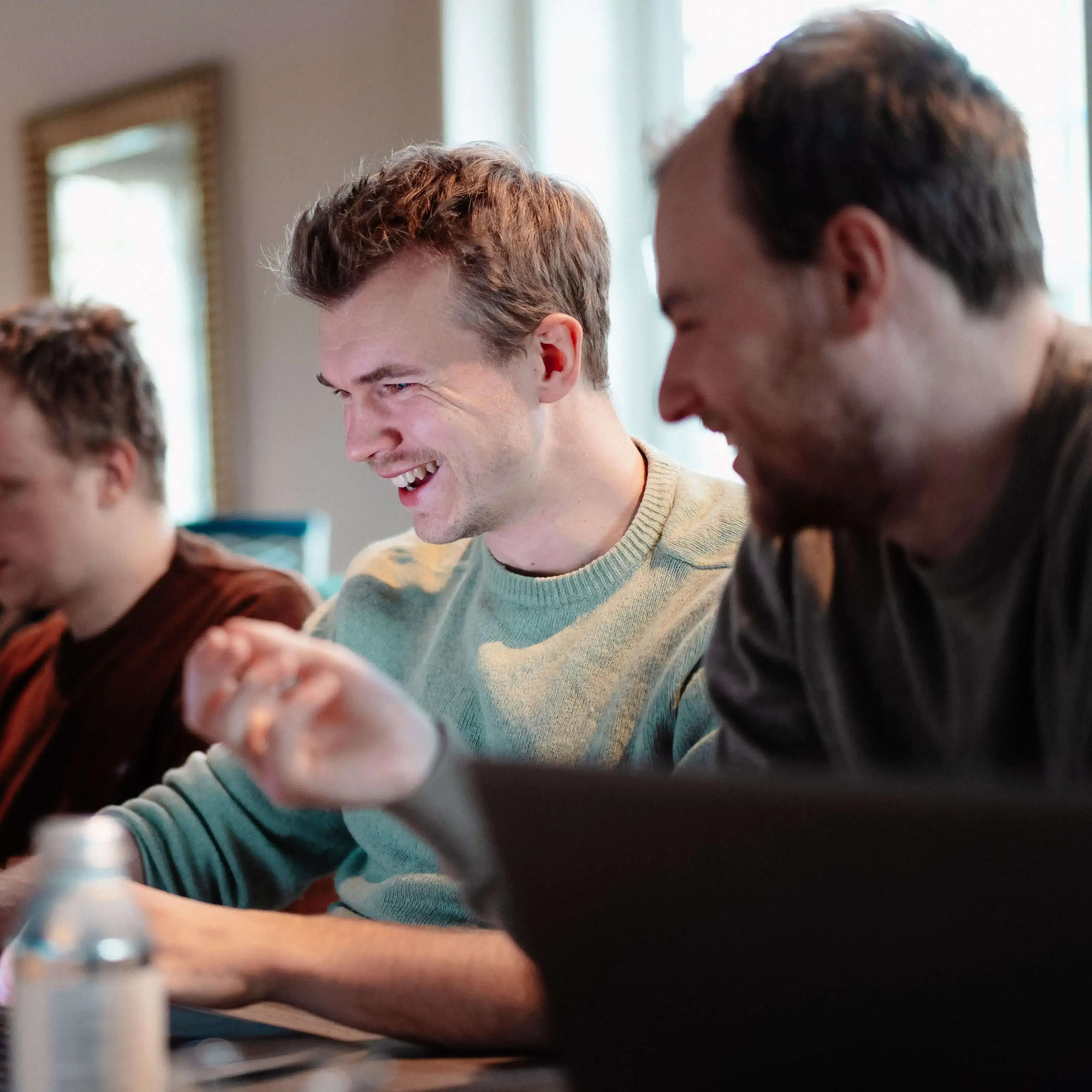 viadee Berater haben Spaß bei der Arbeit vorm Laptop